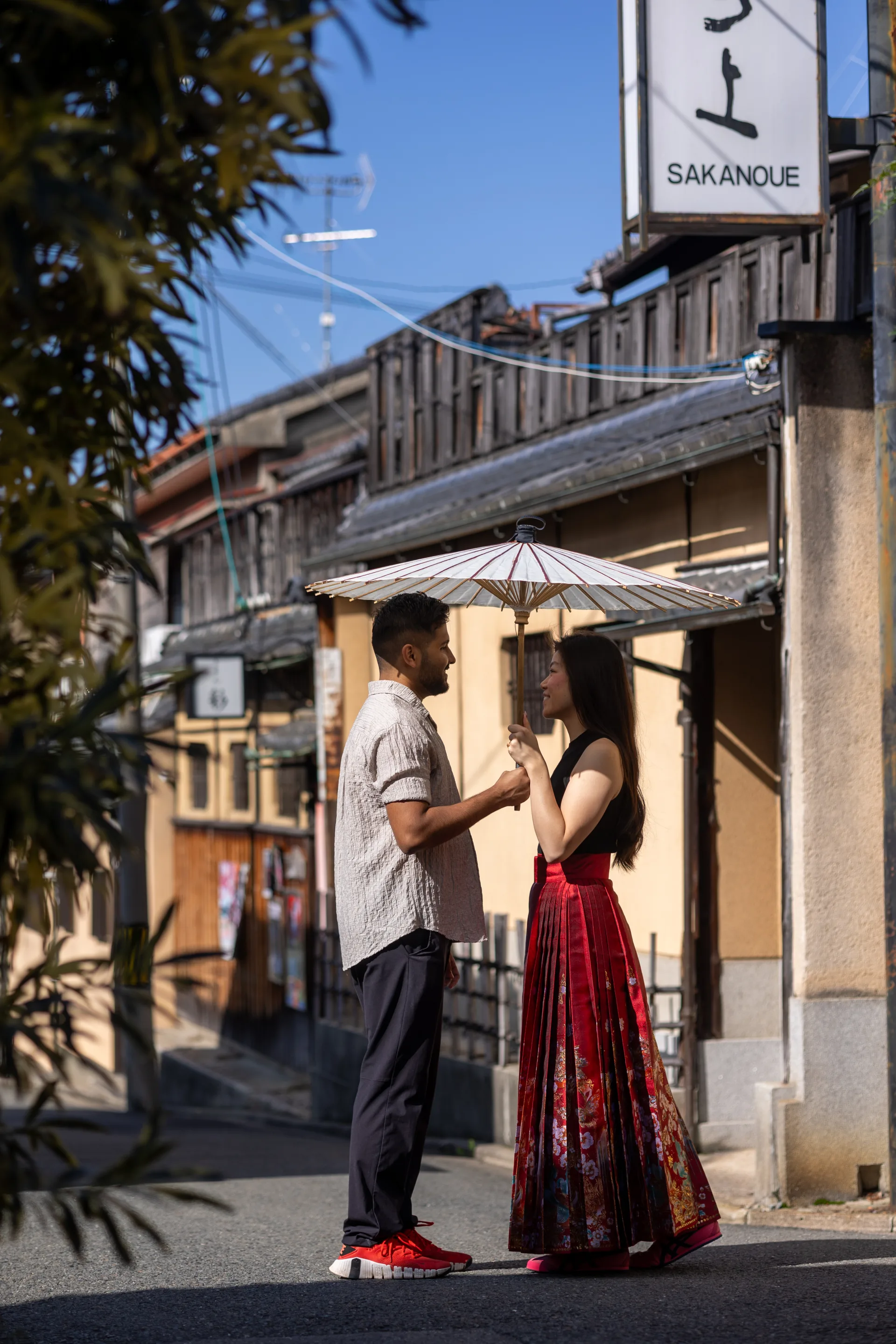 Vivian and Ritam under a paper umbrella on a Kyoto street